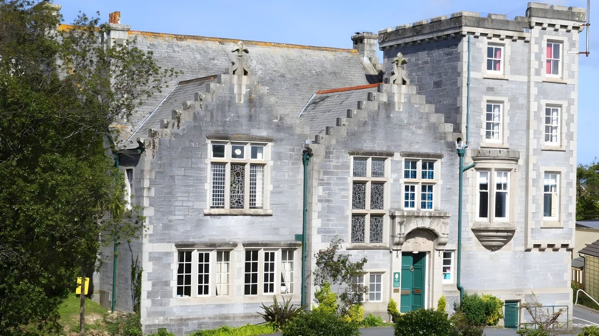 Das historische Stone Castle auf dem Gelände der Truro High School for Girls ist von grünen Pflanzen umgeben.