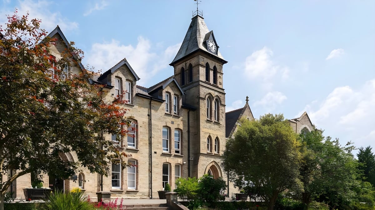 Das gotische Hauptgebäude der Truro School wird von Bäumen umgeben und steht in einer grünen Parkanlage.