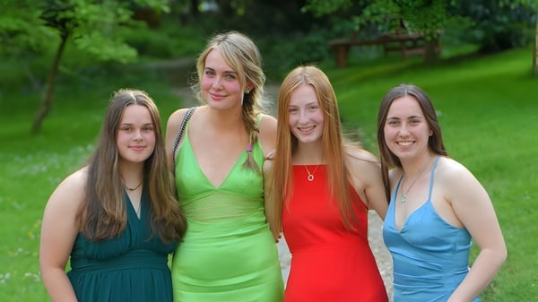 Vier Schülerinnen der Truro School stehen zusammen in einer grünen Außenanlage.