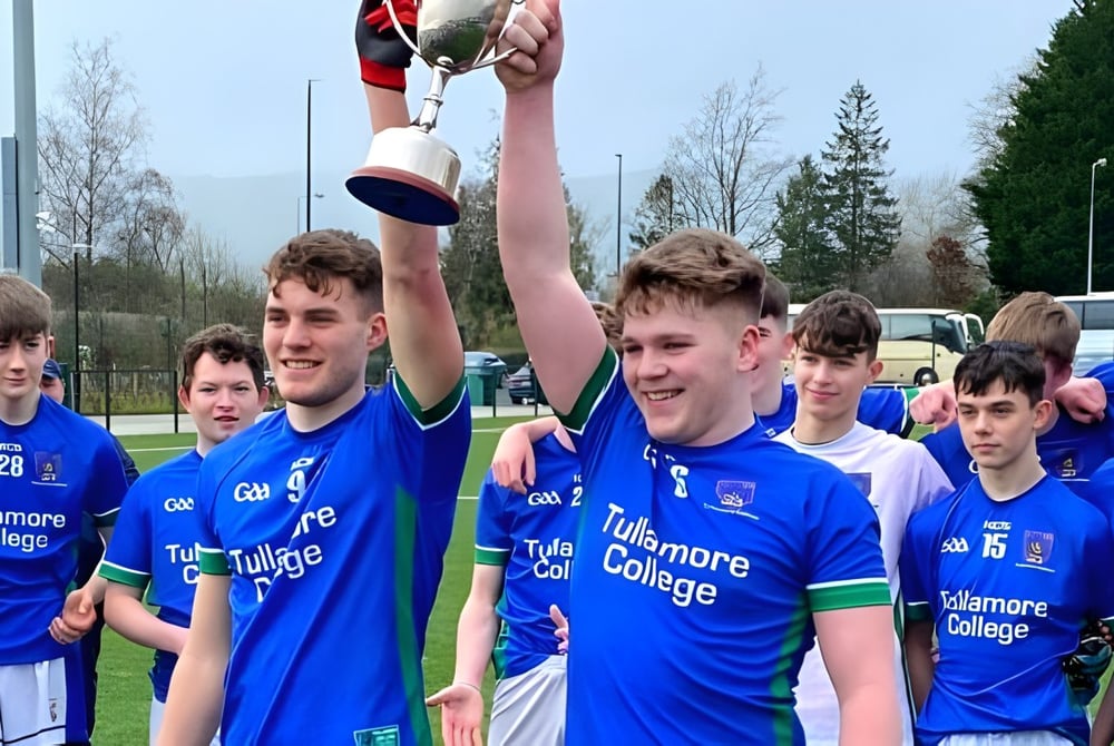 Eine Gruppe junger Fußballspieler in blauen Trikots feiert ihren Sieg auf dem Sportplatz des Tullamore College.
