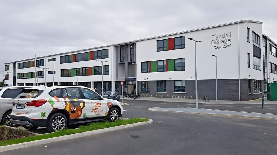 Das moderne mehrstöckige Schulgebäude mit bunten Fenstern auf dem Campus des Tyndall College unter bewölktem Himmel.