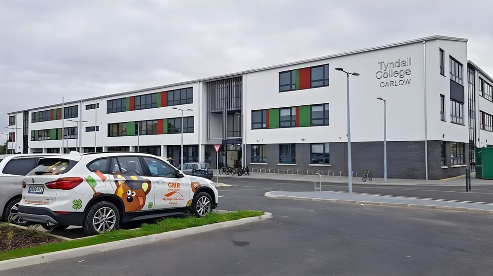 Das moderne mehrstöckige Schulgebäude mit bunten Fenstern auf dem Campus des Tyndall College unter bewölktem Himmel.