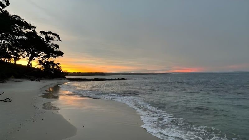 Ein ruhiger Strand mit sanften Wellen und Sonnenuntergang am UC Lake Ginninderra.