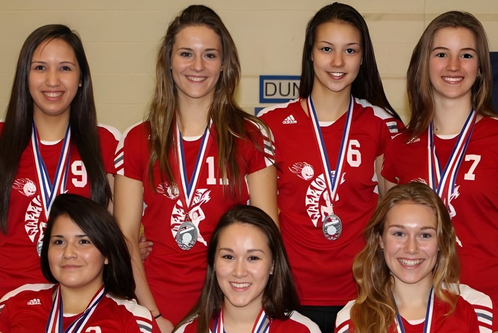 Eine Gruppe Schülerinnen der Ucluelet Secondary School trägt rote Sporttrikots mit der Nummer 9 und zeigt ihre Medaillen.