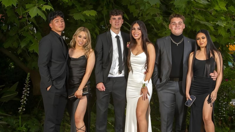 Eine Gruppe gut gekleideter Schülerinnen und Schüler steht im grünen Außenbereich der Underdale High School zusammen.