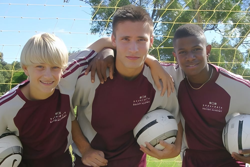Drei Schülerinnen und Schüler der Underdale High School posieren gemeinsam draußen auf dem Sportplatz.