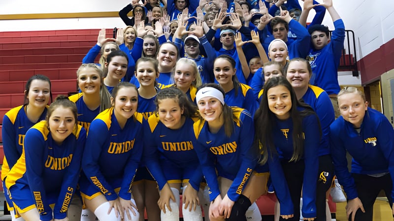 Eine Gruppe Schülerinnen der Union High School steht in blauen und gelben Uniformen in einer Sporthalle zusammen.