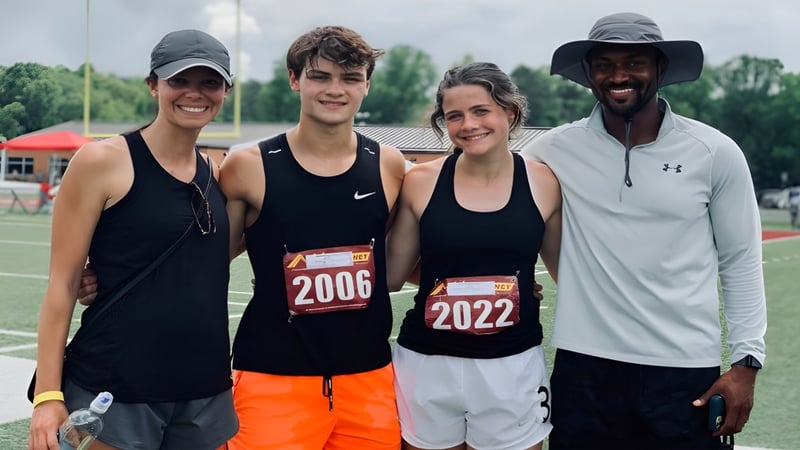 Vier Athleten stehen gemeinsam auf dem Sportfeld der Unity Christian High School während eines sportlichen Ereignisses.