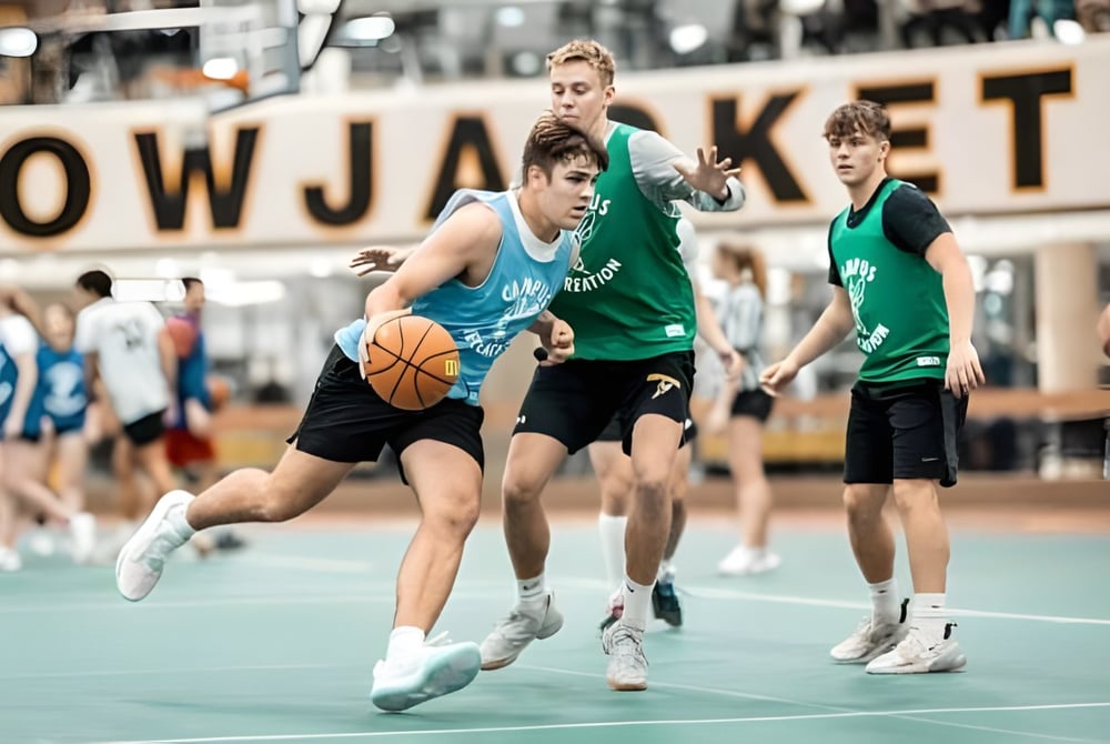 Eine Gruppe Schüler spielt Basketball in der Halle der University of Wisconsin-Superior vor einem großen LOWJACKETS-Schild.