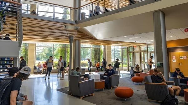 Menschen in der offenen Lobby mit Holzakzenten und Glaswänden an der University of Wisconsin-Superior.
