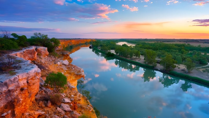 Ein ruhiger Fluss verläuft durch eine bewaldete Landschaft mit bunten Klippen, zu sehen in der Umgebung der Unley High School.