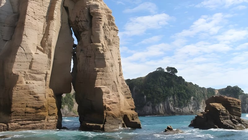 Felsenformationen ragen aus türkisfarbenem Wasser, umgeben von Vegetation und Bergen, nahe dem Upper Hutt College.