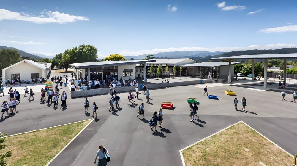 Außerhalb des Upper Hutt College ist ein belebter Marktplatz mit verschiedenen Ständen und Bergen im Hintergrund zu sehen.
