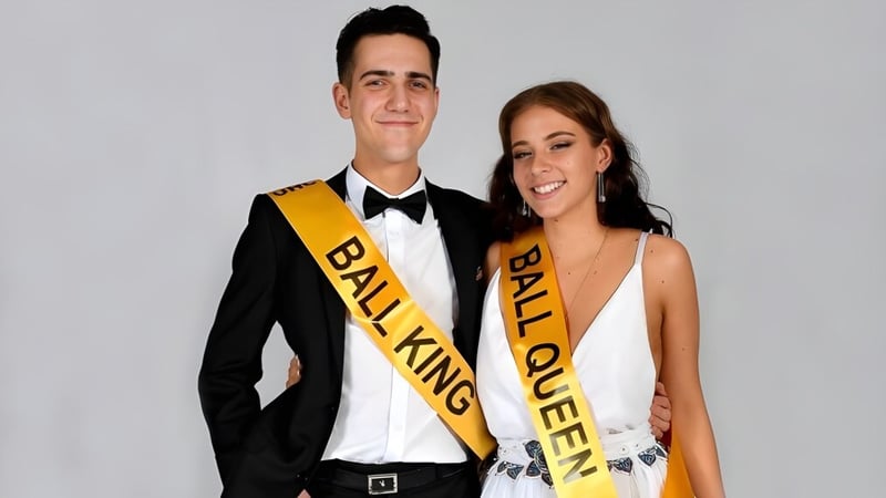 Ein Mann im schwarzen Anzug und eine Frau im weißen Kleid posieren zusammen am Upper Hutt College.