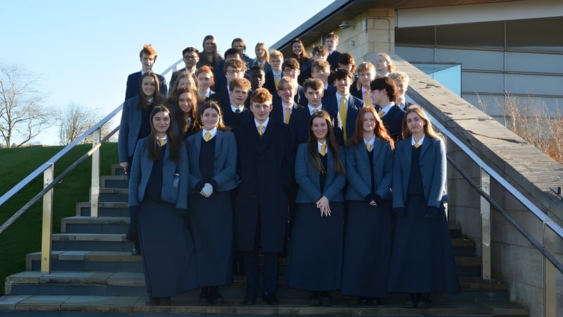 Eine Gruppe von Schülern der Uppingham School steht auf der Treppe vor einem Gebäude mit Glasfassade.