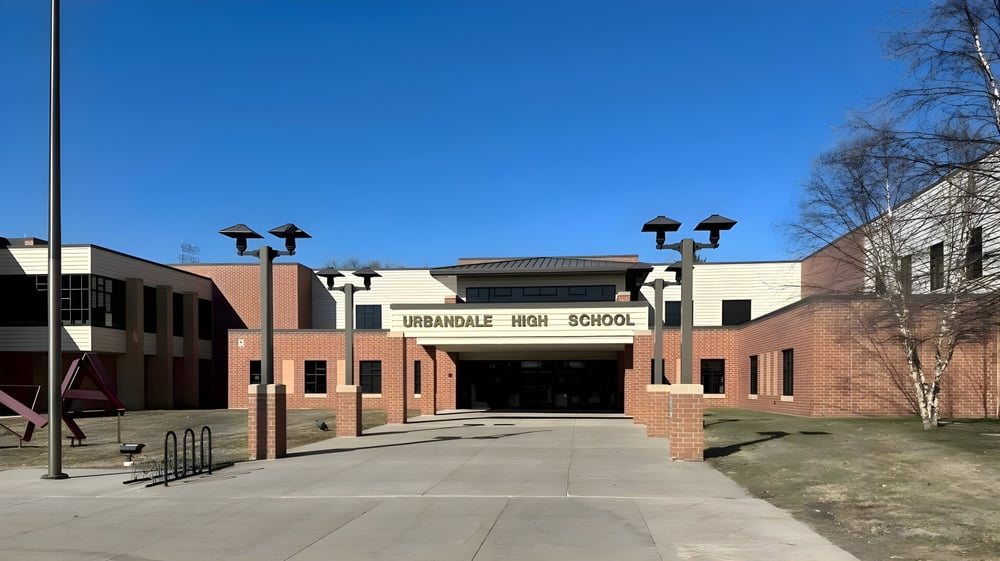 Das Backsteingebäude des Urbandale Community School District ist von einem gepflasterten Weg und Straßenlaternen umgeben.