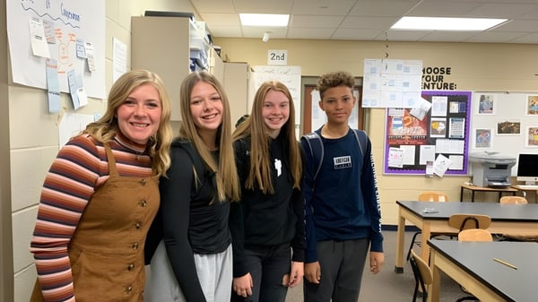 Vier Schülerinnen stehen gemeinsam in einem Flur der Urbandale High School vor pädagogischen Postern.