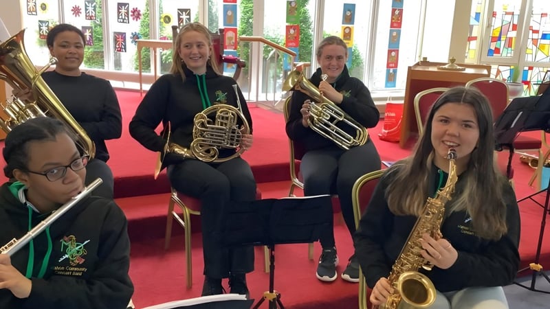 Eine Gruppe junger Musiker spielt auf der Bühne der Ursuline Secondary School in Cork Blechblasinstrumente.