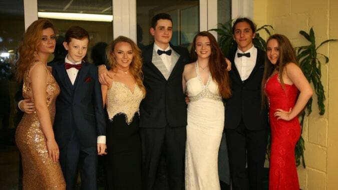 Schüler der Ursuline Secondary School in Cork bei einer formellen Veranstaltung vor Pflanzen und einem Türrahmen.