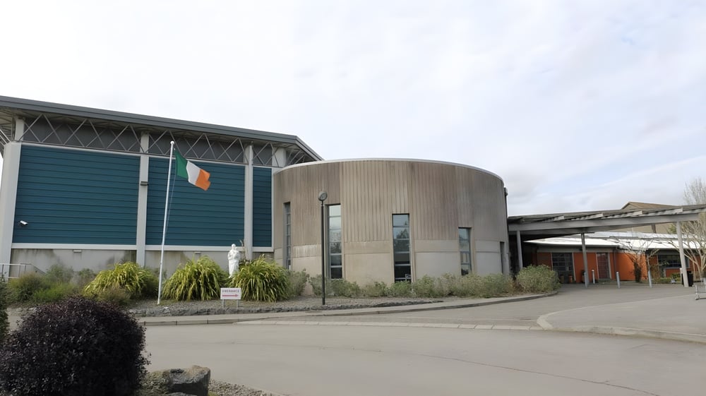 Das moderne mehrstöckige Gebäude der Ursuline Secondary School in Cork mit einer gewölbten zylindrischen Architektur steht vor einer gepflasterten Fläche.