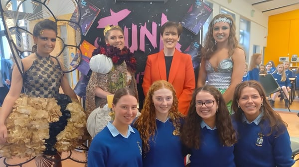 Eine Gruppe von Schülerinnen der Ursuline Secondary School Thurles posiert vor einem UN-Logo in der Schule.