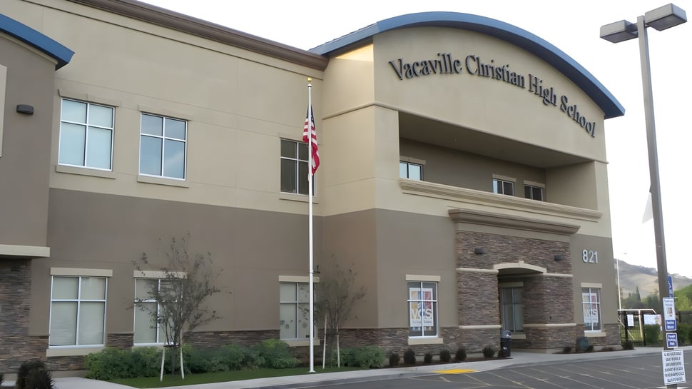 Das mehrstöckige Gebäude der Vacaville Christian School ist mit einem Schild an der Fassade und sichtbarer Landschaftsgestaltung im Vordergrund zu sehen.