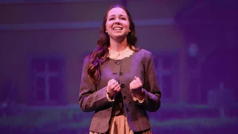 Eine Schülerin der Valley Christian High School steht auf der Bühne vor lila Hintergrund.