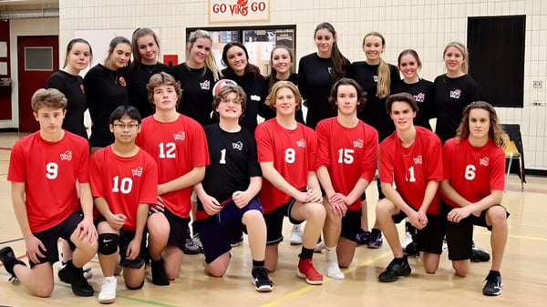 Eine Gruppe Schüler der Valleyview Secondary School in roten und schwarzen Uniformen posiert in der Turnhalle vor einem Go Vikings Schild.