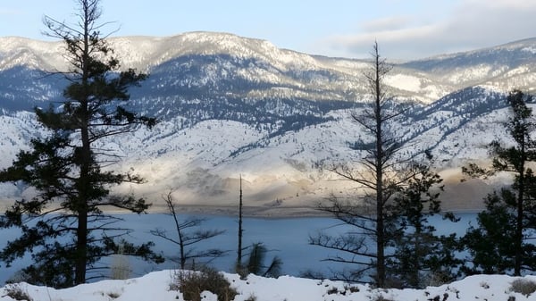 Schulgelände der Valleyview Secondary School mit Blick auf verschneite Berge und einen See im Vordergrund.