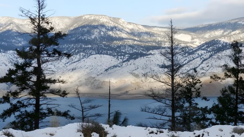 Schulgelände der Valleyview Secondary School mit Blick auf verschneite Berge und einen See im Vordergrund.
