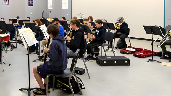 Schüler der Valley View Secondary bei einer Musikprobe mit verschiedenen Instrumenten im Hintergrund.