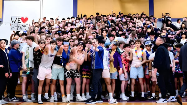 Eine Gruppe von Schülern im Innenraum mit einem Schild 'We ♥ SHAMS' auf dem Campus des Vancouver Community College.
