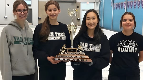 Vier Schülerinnen mit Van Tech Phys Ed Shirts der Vancouver Technical Secondary School halten gemeinsam einen Pokal.