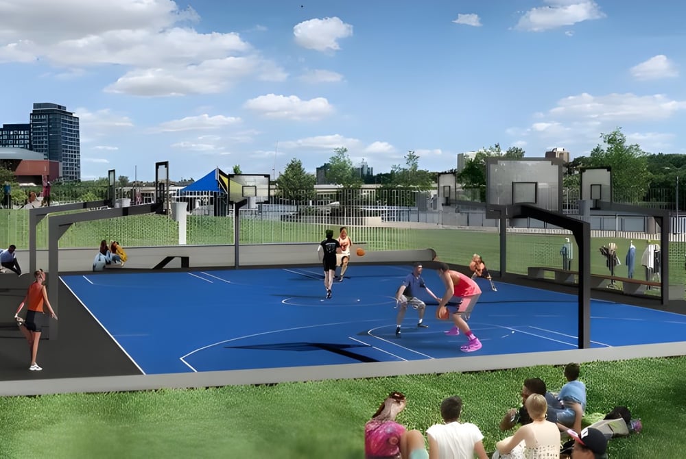 Schüler der Victoria Park High School spielen Basketball auf dem bunten Außenplatz mit Gebäuden und Grünflächen im Hintergrund.