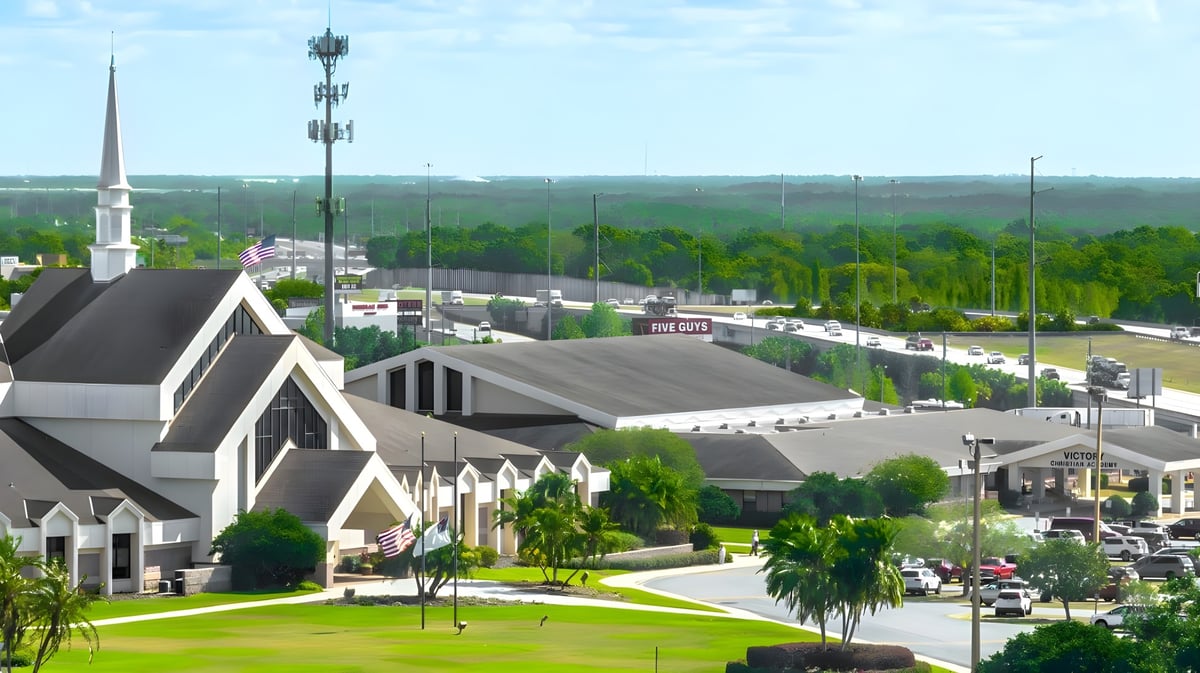 Blick auf die Stadt mit einer markanten Kirche und belebter Straße nahe der Victory Christian Academy.