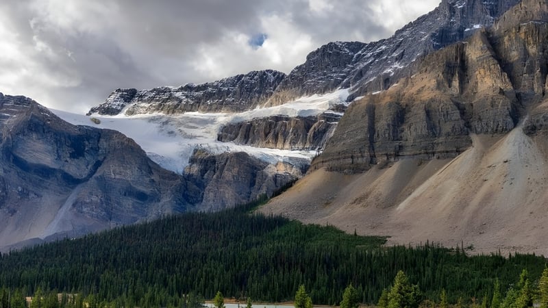 Schneebedeckte Berge und bewaldete Hänge sind in der Landschaft vor der Viking School zu sehen.