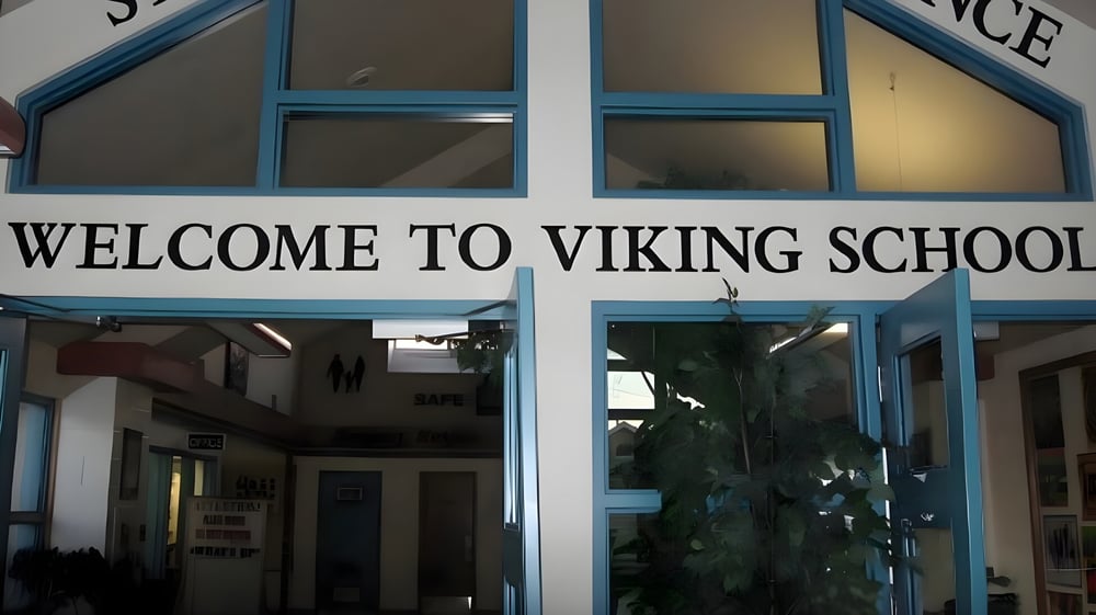 Der Eingang der Viking School mit einem großen Willkommensschild über der Tür und Blick in den Flur durch die Glasfenster.