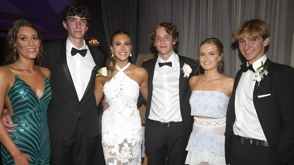 Eine Gruppe von Personen in formeller Kleidung posiert bei einer Veranstaltung auf dem Campus der Villiers School.