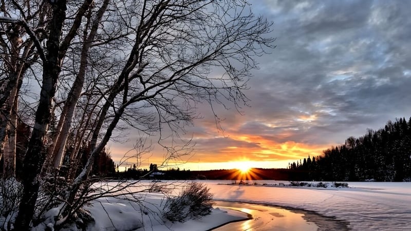 Winterlandschaft mit zugefrorenem See und schneebedeckten Bäumen bei Sonnenuntergang nahe der Vimy Ridge Academy.