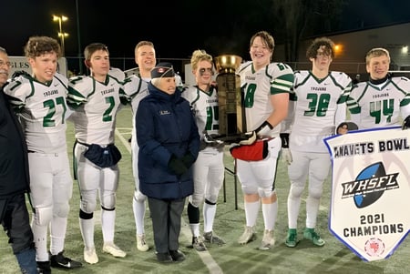 Fußballspieler des Institut Collégial Vincent Massey Collegiate halten auf dem Spielfeld bei Nacht eine Trophäe.
