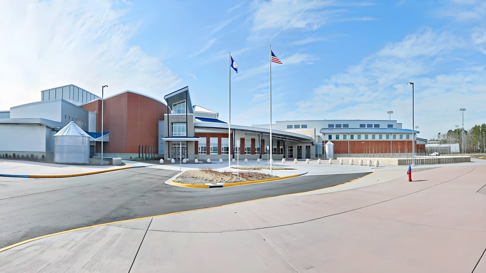 Das moderne mehrstöckige Schulgebäude mit Glasfassade und einer amerikanischen Flagge ist Teil des Virginia Beach City Public School District.
