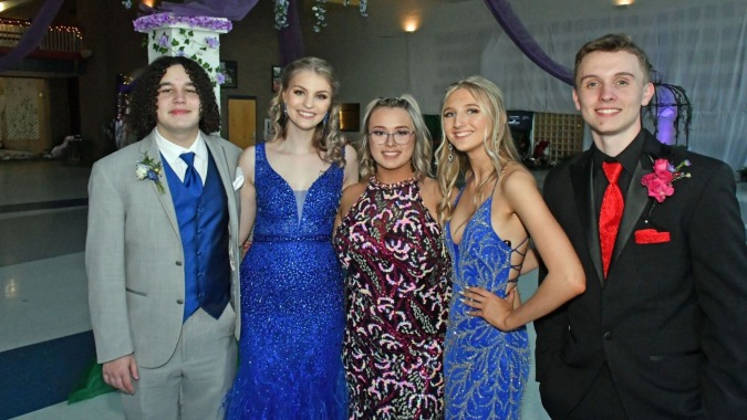 Eine Gruppe von fünf Personen in formeller Kleidung bei einer Feier auf dem Campus des Virginia College.