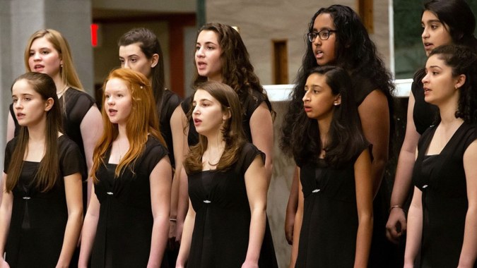 Eine Gruppe junger Frauen in schwarzen Kleidern steht gemeinsam bei einer Aufführung am Virginia College.