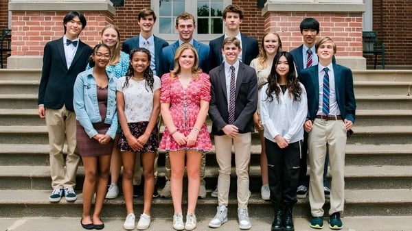 Eine Gruppe Schülerinnen und Schüler steht vor dem Backsteingebäude der Virginia Episcopal School und posiert für ein Gruppenfoto.