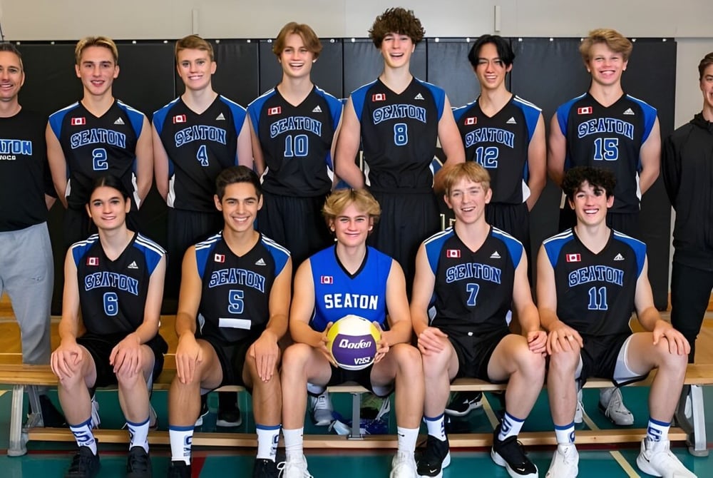 Das Volleyballteam der W. L. Seaton Secondary School posiert gemeinsam in der Turnhalle.