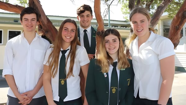 Eine Gruppe von fünf Schülerinnen und Schülern steht vor einem Gebäude auf dem Campus des Waimea College.