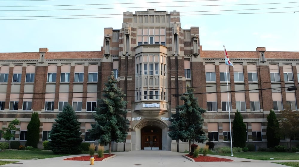 Das historische Hauptgebäude des Walkerville Collegiate Institute umgeben von Bäumen und gepflegtem Rasen.