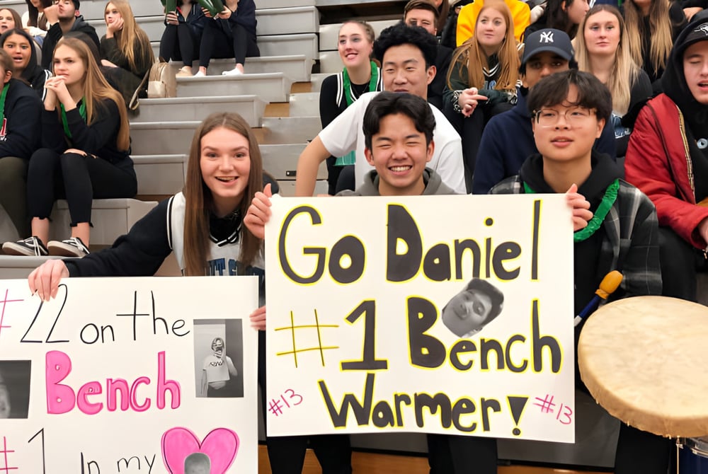Eine Gruppe Schüler der Walnut Grove Secondary School hält bei einer Veranstaltung Schilder hoch und jubelt.