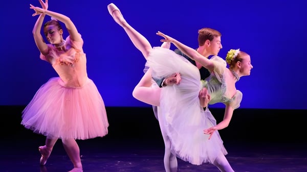 Schüler der Walnut Hill School for the Arts führen eine Ballett-Aufführung auf einer Bühne mit blauem Hintergrund auf.