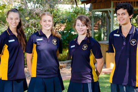 Vier Schüler des Wanneroo Secondary College stehen gemeinsam in einem natürlichen Umfeld mit Bäumen im Hintergrund.